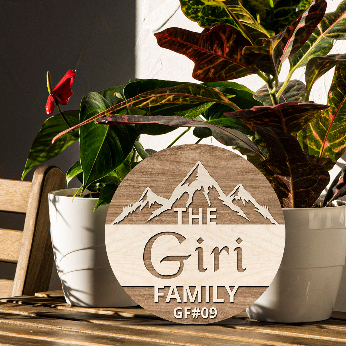 Mountain-range round wooden family name plate styled on an entrance wall