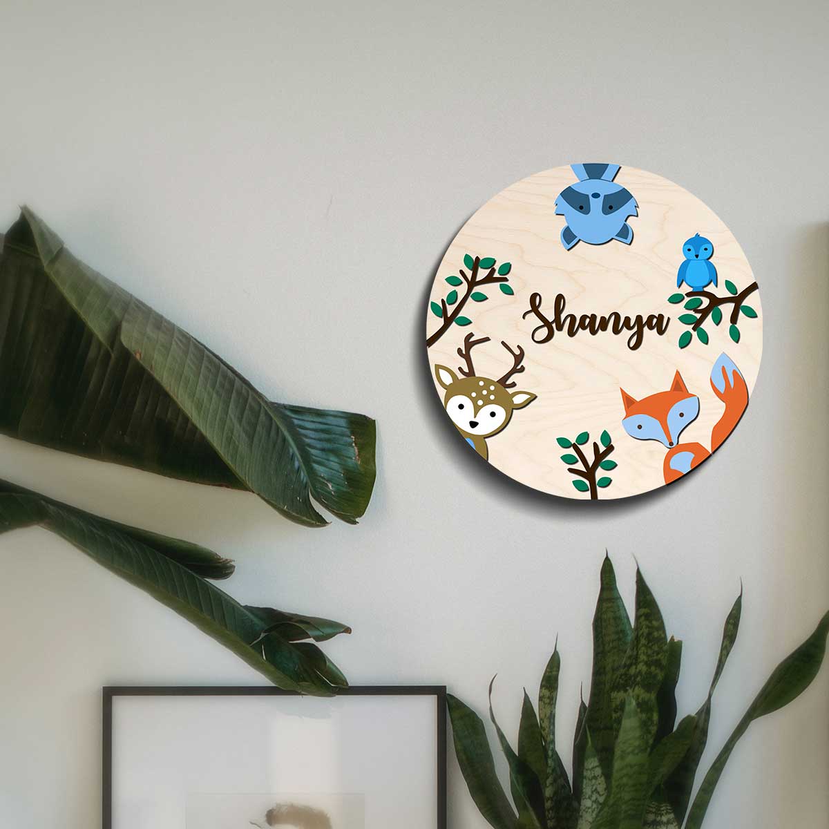 Round safari animal name plate on a bedroom door with layered woodland animals