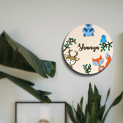 Round safari animal name plate on a bedroom door with layered woodland animals