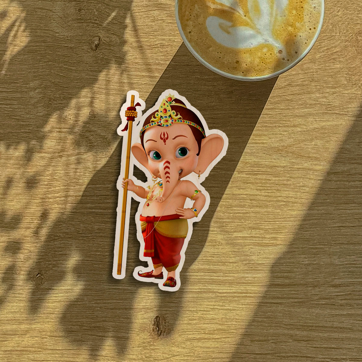 God fridge magnet on a clean backdrop showing cartoon baby Ganesha with staff and tiara silhouette.