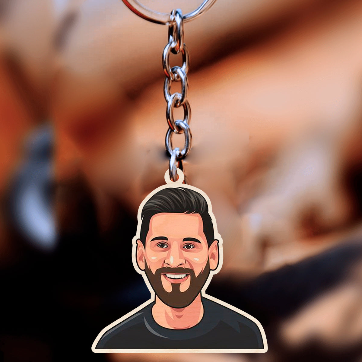 Messi keychain in 3x3 inch birch — cartoon bust in plain black tee, no club jersey