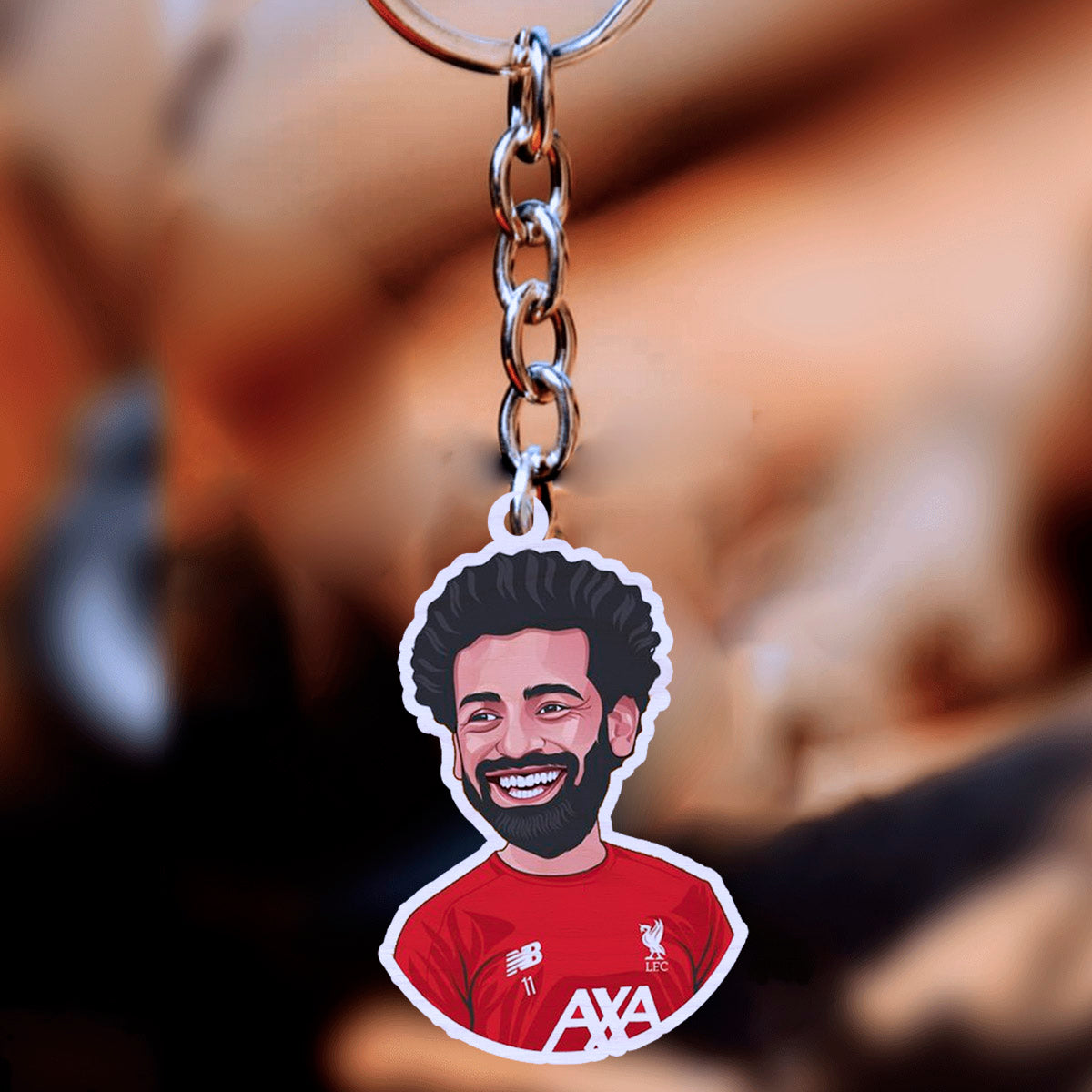 Wooden keychain on a clean backdrop showing salah caricature with signature curls in the 2021-22.