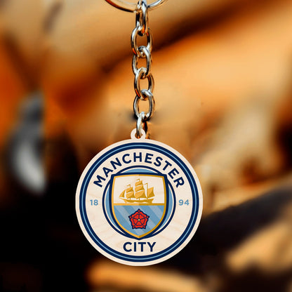Detail of the football keychain, with light-blue ship + red rose roundel with 1894 founding date, in birch wood.
