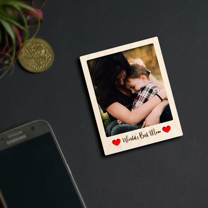 Alternate angle on the mom fridge magnet, showing polaroid frame with Mom-tribute cursive, in birch wood.