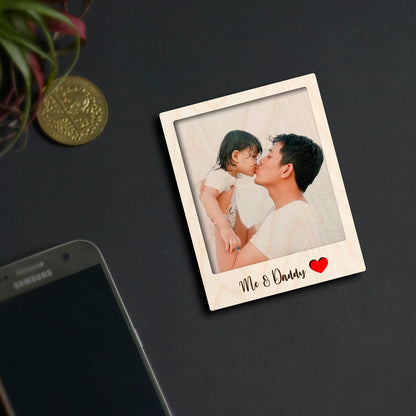 Alternate angle on the dad fridge magnet, showing polaroid with 'Dad' label, in birch wood.