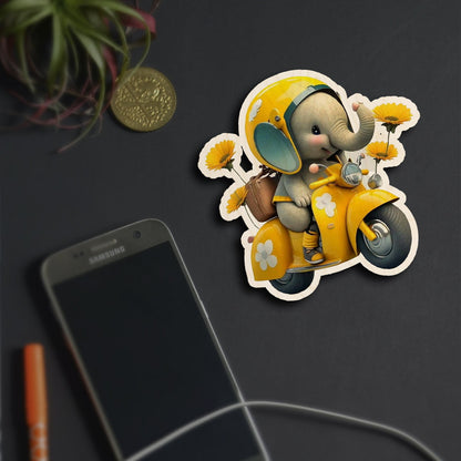 Alternate angle on the kids fridge magnet, showing cartoon baby elephant on yellow Vespa with sunflowers, in birch wood.