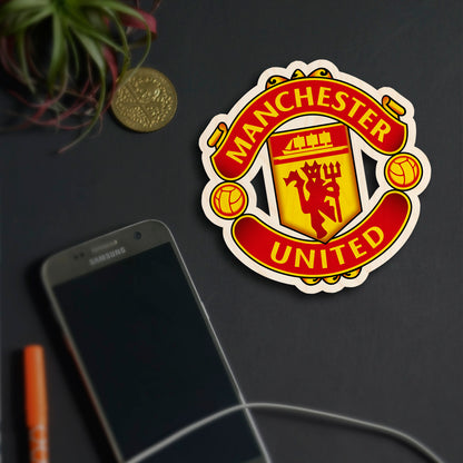 Detail shot of the manchester united fridge magnet in birch wood with magnet back and clean backdrop styling.
