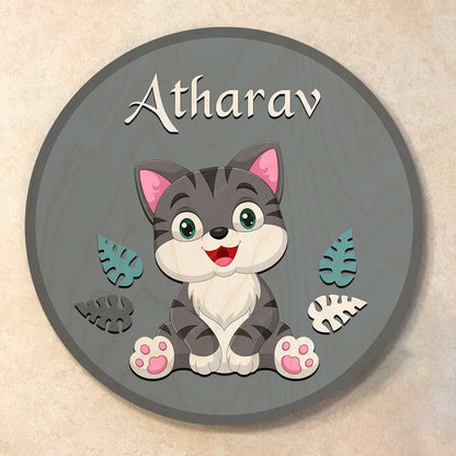 Cute grey tabby cat with wooden leaf cutouts on round grey cat name plate for kids