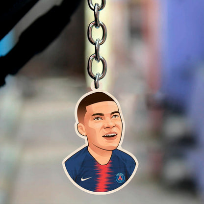 Alternate angle on the football keychain, showing mbappe cartoon in PSG navy + red center-stripe kit with.