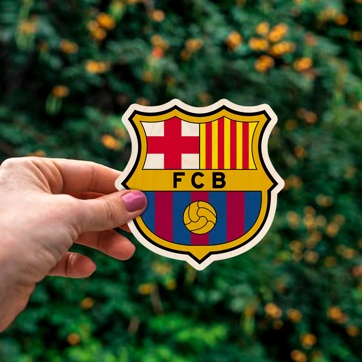 Detail crop of the fc barcelona fridge magnet, with fCB heraldic crest with Catalan flag, on birch wood face.