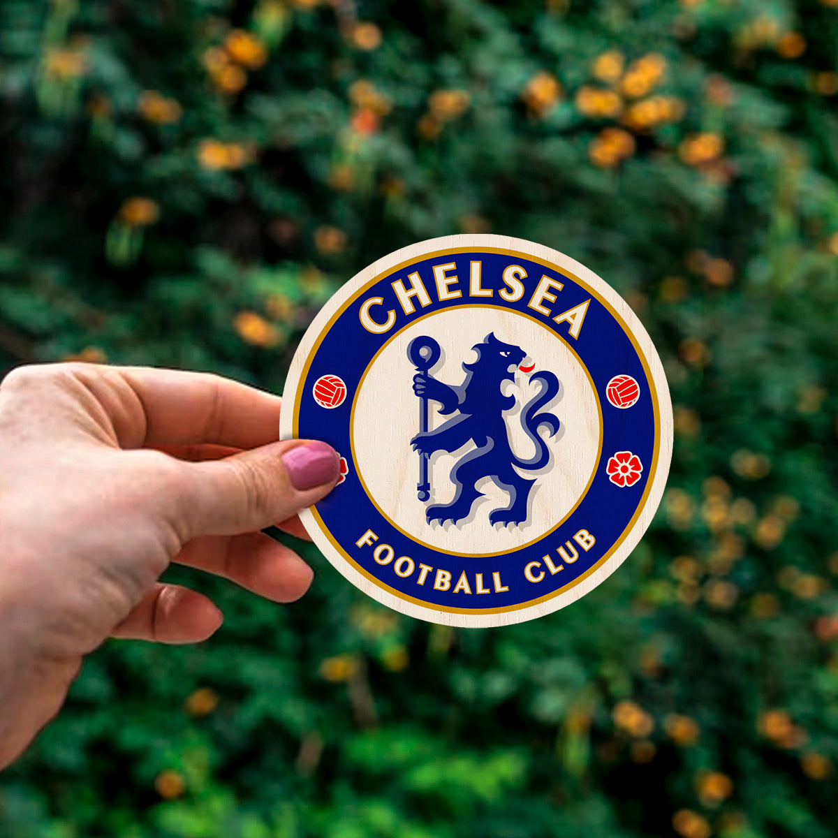 Detail crop of the chelsea fridge magnet, with chelsea blue rampant lion roundel with gold ring text, on birch wood face.