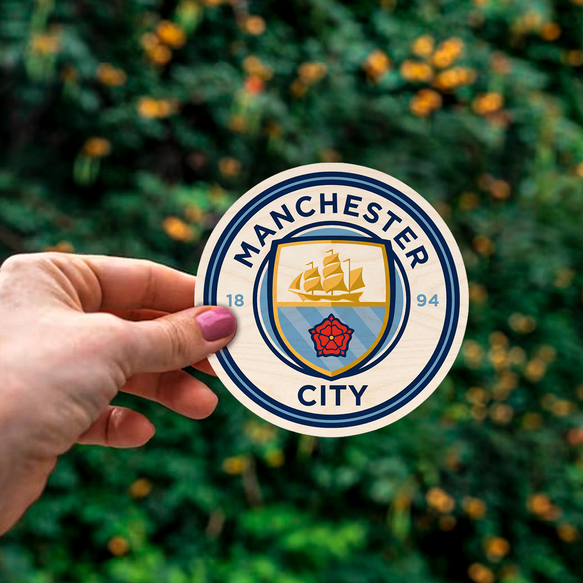 Detail crop of the manchester city fridge magnet, with sky-blue ship + red rose roundel with 1894 founding date.