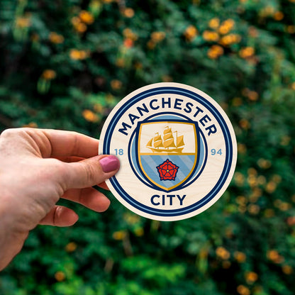 Detail crop of the manchester city fridge magnet, with sky-blue ship + red rose roundel with 1894 founding date.