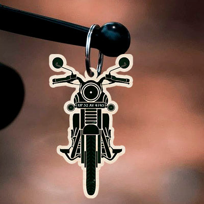 Detail of the bike keychain royal enfield, with bullet silhouette cutout with real custom number-plate slot, in birch wood.