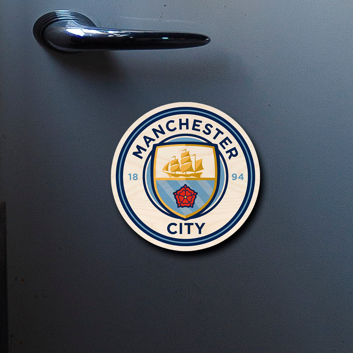 On-fridge lifestyle shot of the manchester city fridge magnet, clipped to a stainless surface.