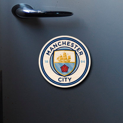 On-fridge lifestyle shot of the manchester city fridge magnet, clipped to a stainless surface.