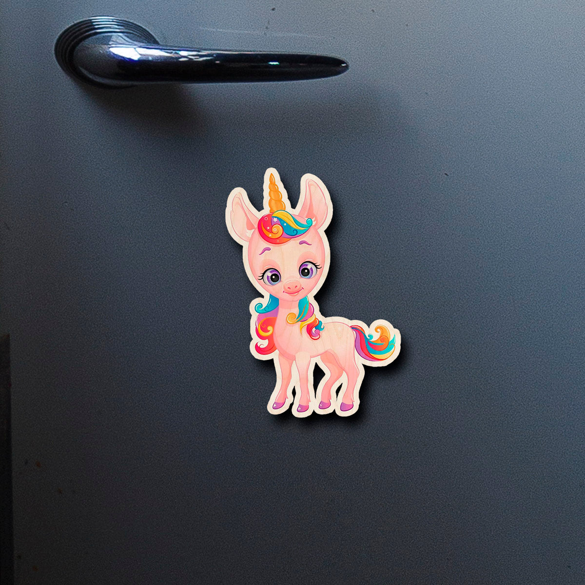On-fridge lifestyle shot of the kids fridge magnet, showing cartoon unicorn silhouette with rainbow mane and tail.