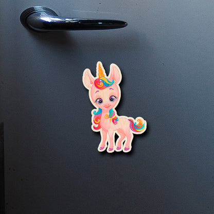 On-fridge lifestyle shot of the kids fridge magnet, showing cartoon unicorn silhouette with rainbow mane and tail.