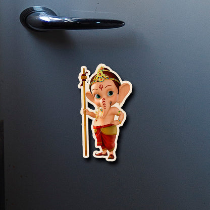 On-fridge lifestyle shot of the god fridge magnet, showing cartoon baby Ganesha with staff and tiara silhouette.