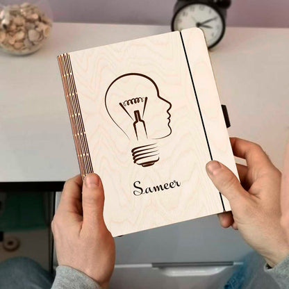 Detail crop on the personalized diary cover, with lightbulb-head silhouette (head profile fused with a bulb).