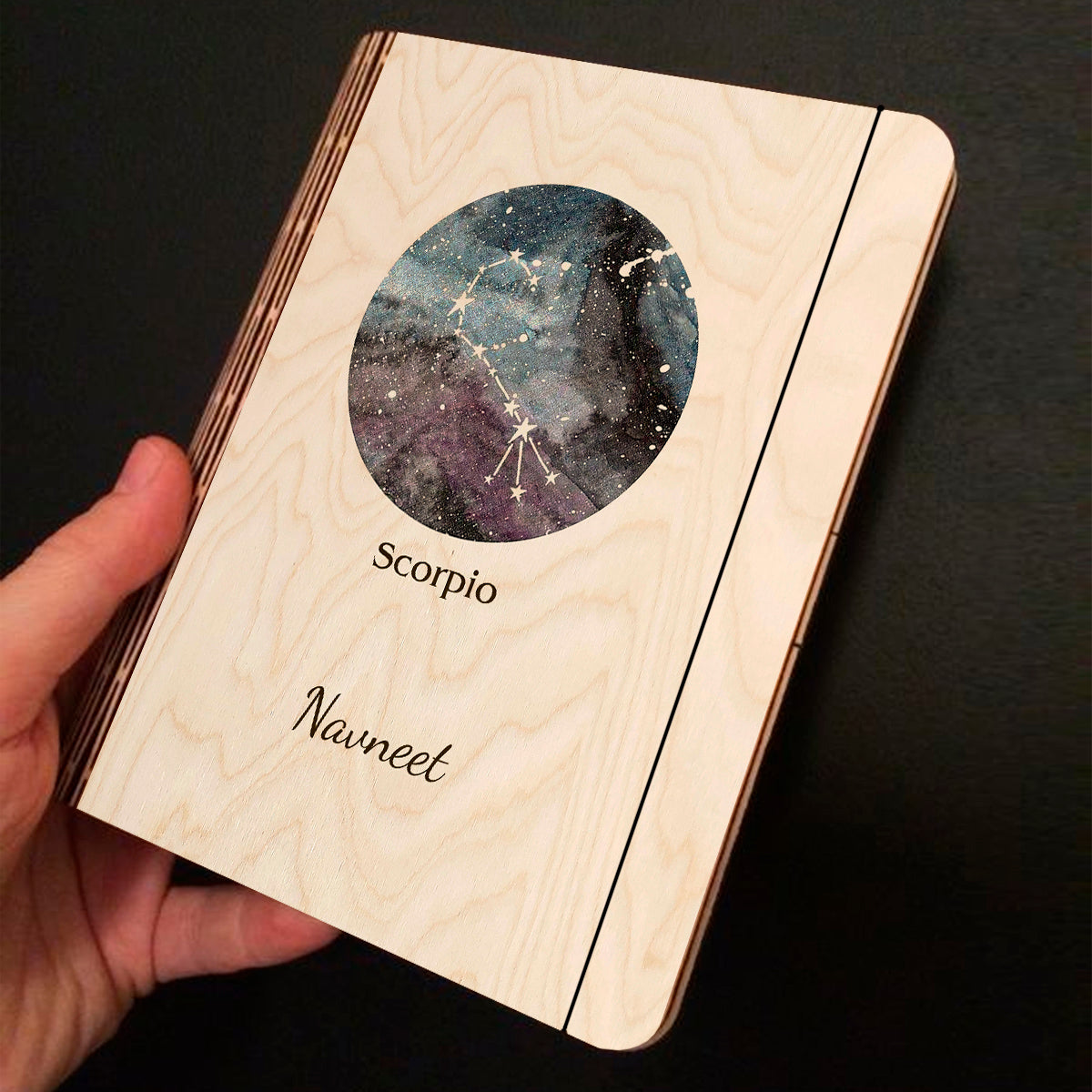 Alternate angle on the personalized diary, showing blue-purple nebula with Scorpio constellation curl and, in birch wood.