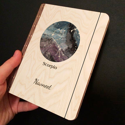 Alternate angle on the personalized diary, showing blue-purple nebula with Scorpio constellation curl and, in birch wood.