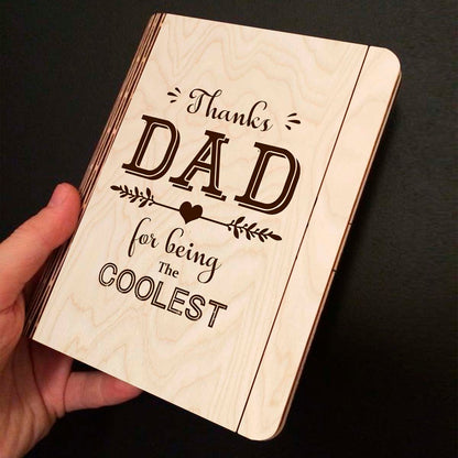 Open spread of the wooden notebook, with thanks DAD' typography with heart-arrow vines, and ruled inner pages.