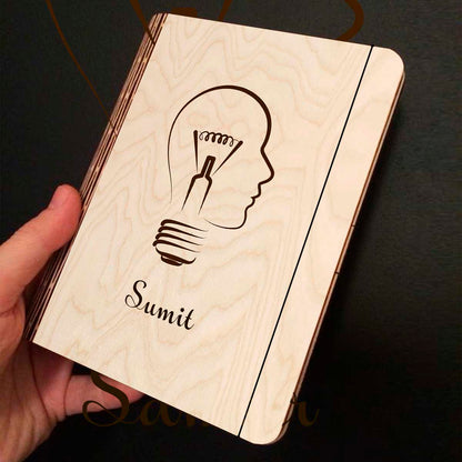 Open spread of the personalized diary, with lightbulb-head silhouette (head profile fused with a bulb).