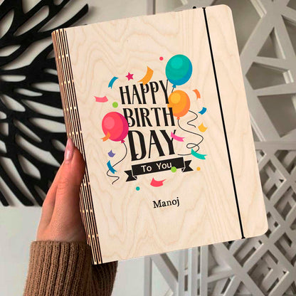 Alternate angle on the personalized diary, showing color-printed balloons + confetti with a custom name slot, in birch wood.