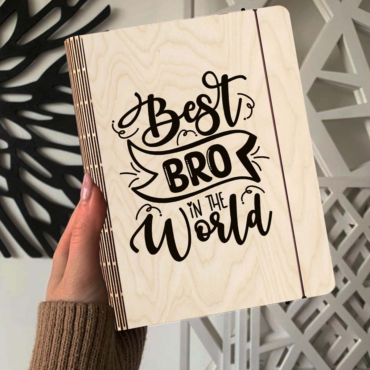 Alternate angle on the wooden notebook, showing hand-lettered brother-tribute script with ribbon banner, in birch wood.