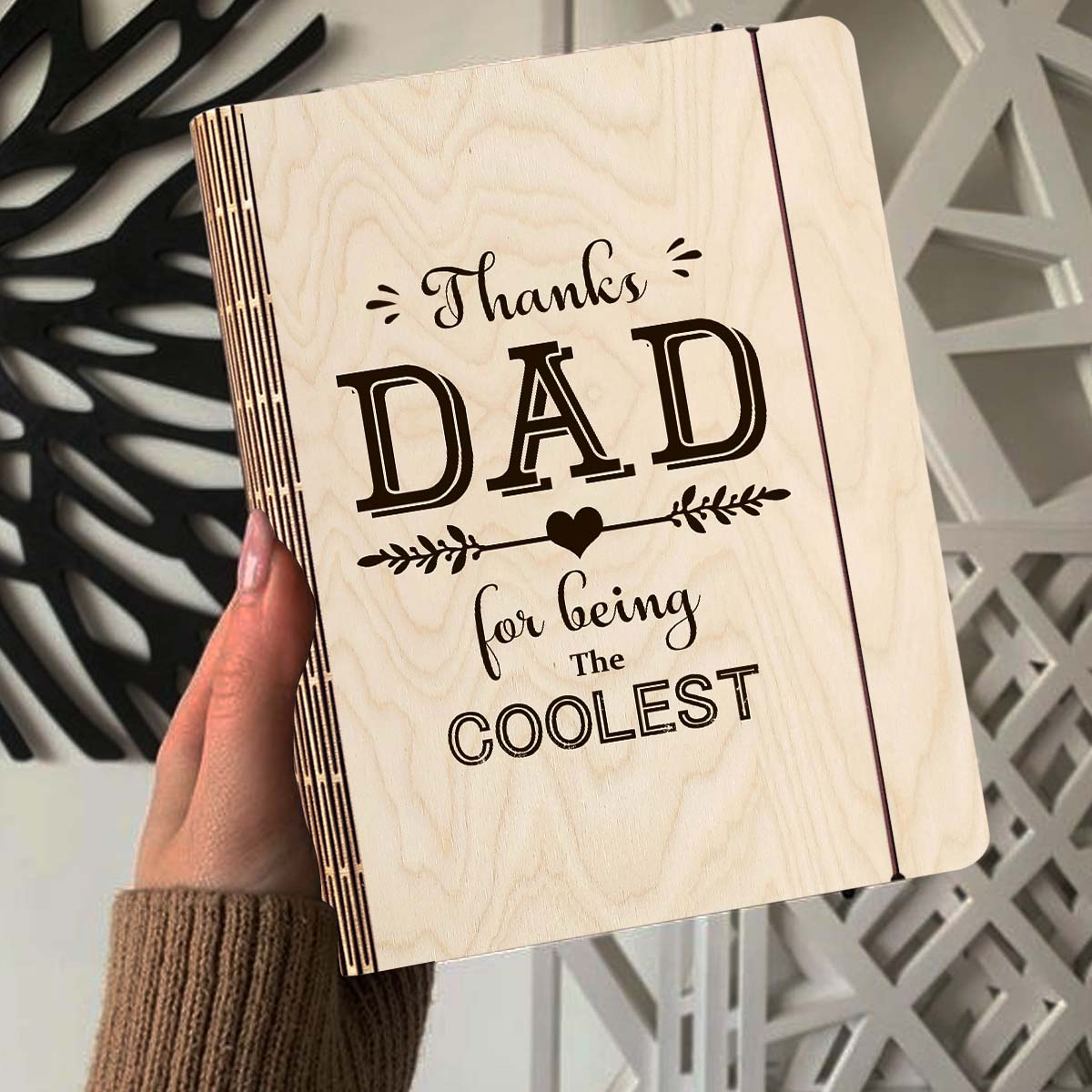 Alternate angle on the wooden notebook, showing thanks DAD' typography with heart-arrow vines, in birch wood.