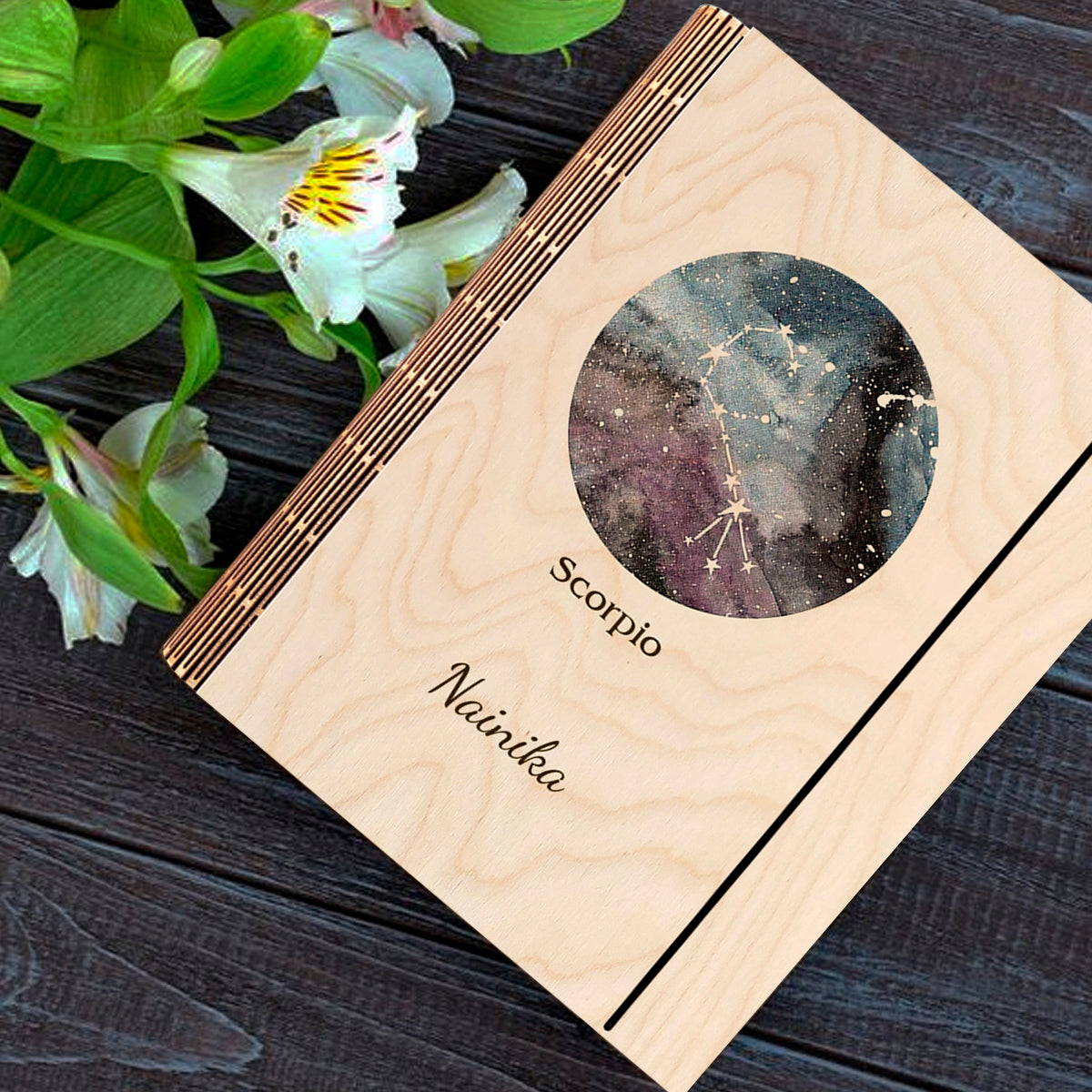 Detail crop on the personalized diary cover, with blue-purple nebula with Scorpio constellation curl and, sharp birch grain.