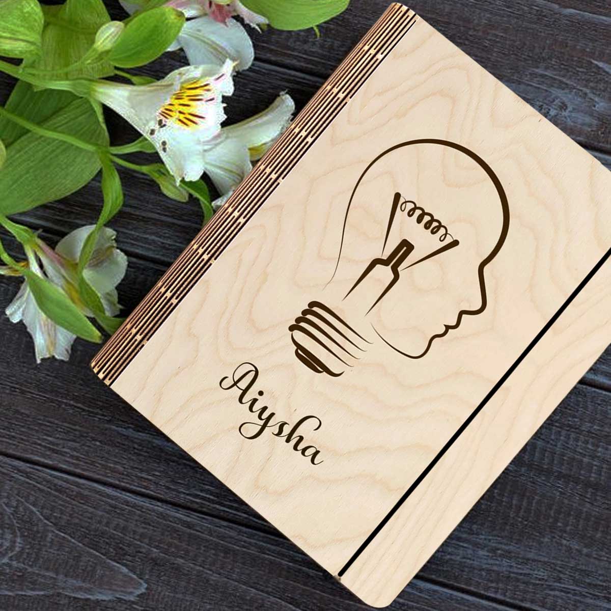 Personalized diary cover on a clean backdrop showing lightbulb-head silhouette (head profile fused with a bulb).