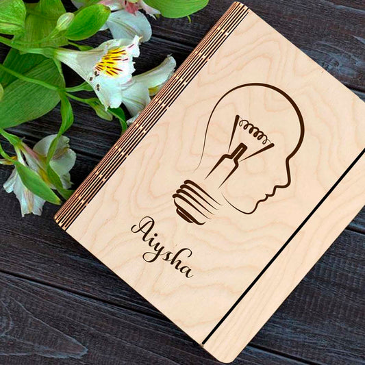Personalized diary cover on a clean backdrop showing lightbulb-head silhouette (head profile fused with a bulb).