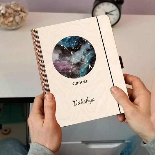 Personalized diary cover on a clean backdrop showing multi-tone nebula with Cancer constellation and custom name.