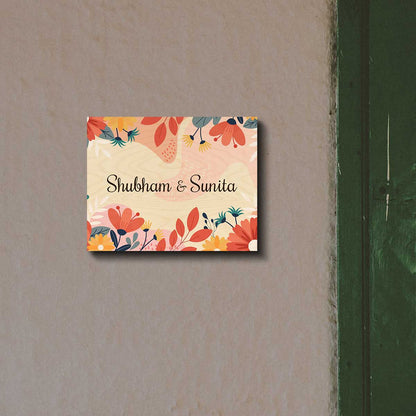 Printed floral name plate on a main door with a name in black script on birch