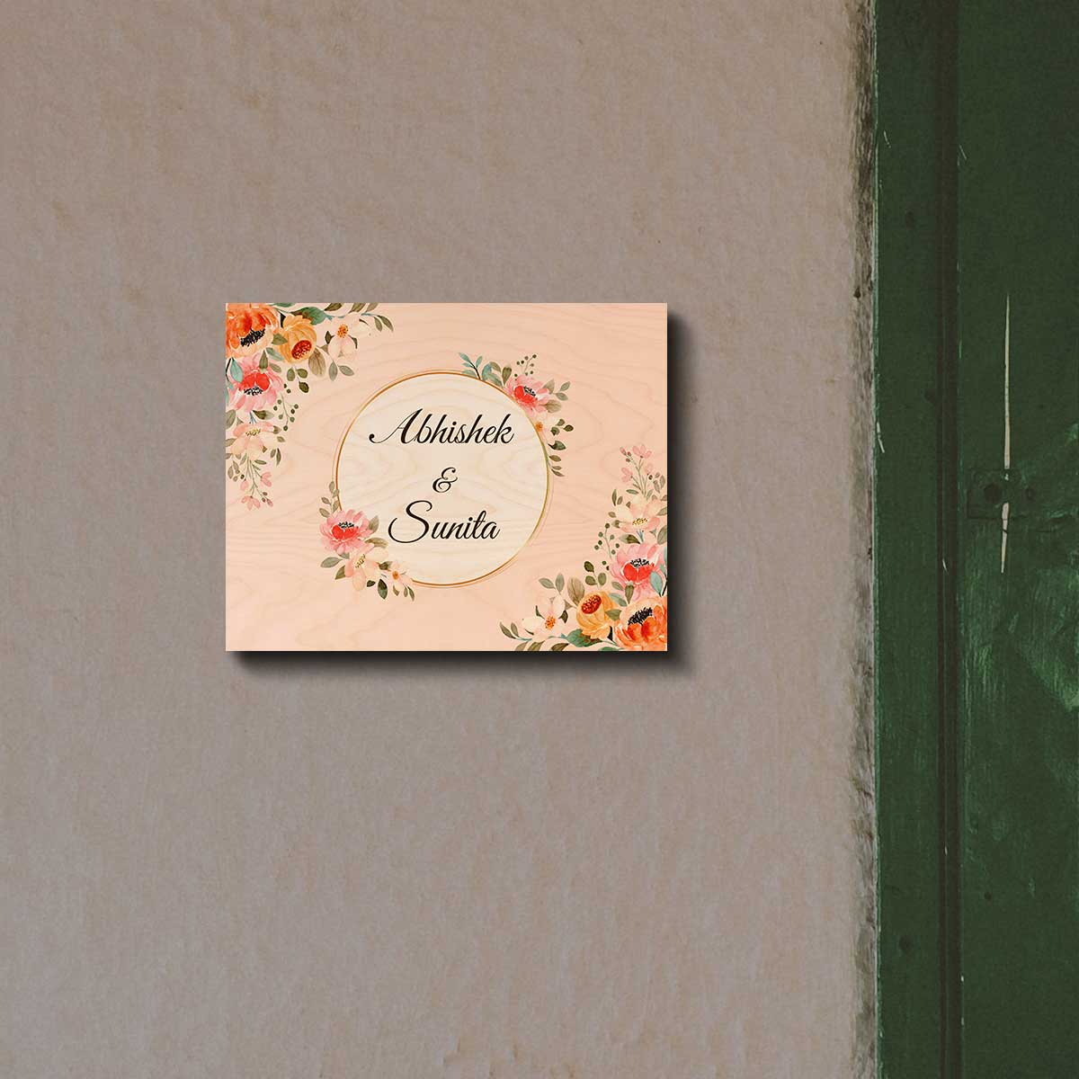 Names in a gold circle and orange peach florals on name board for flat