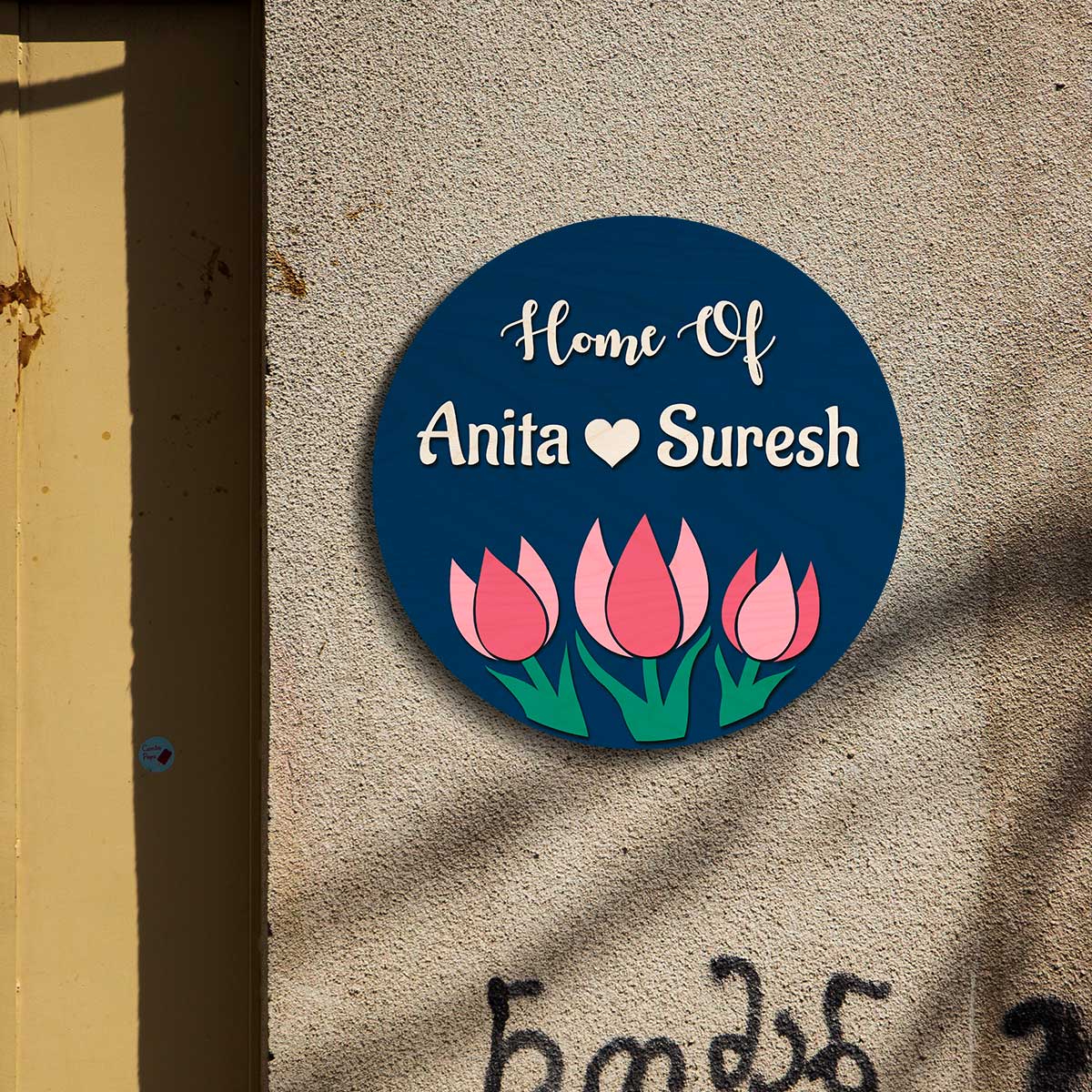 Round navy couple name plate on a main door with raised letters and a small heart