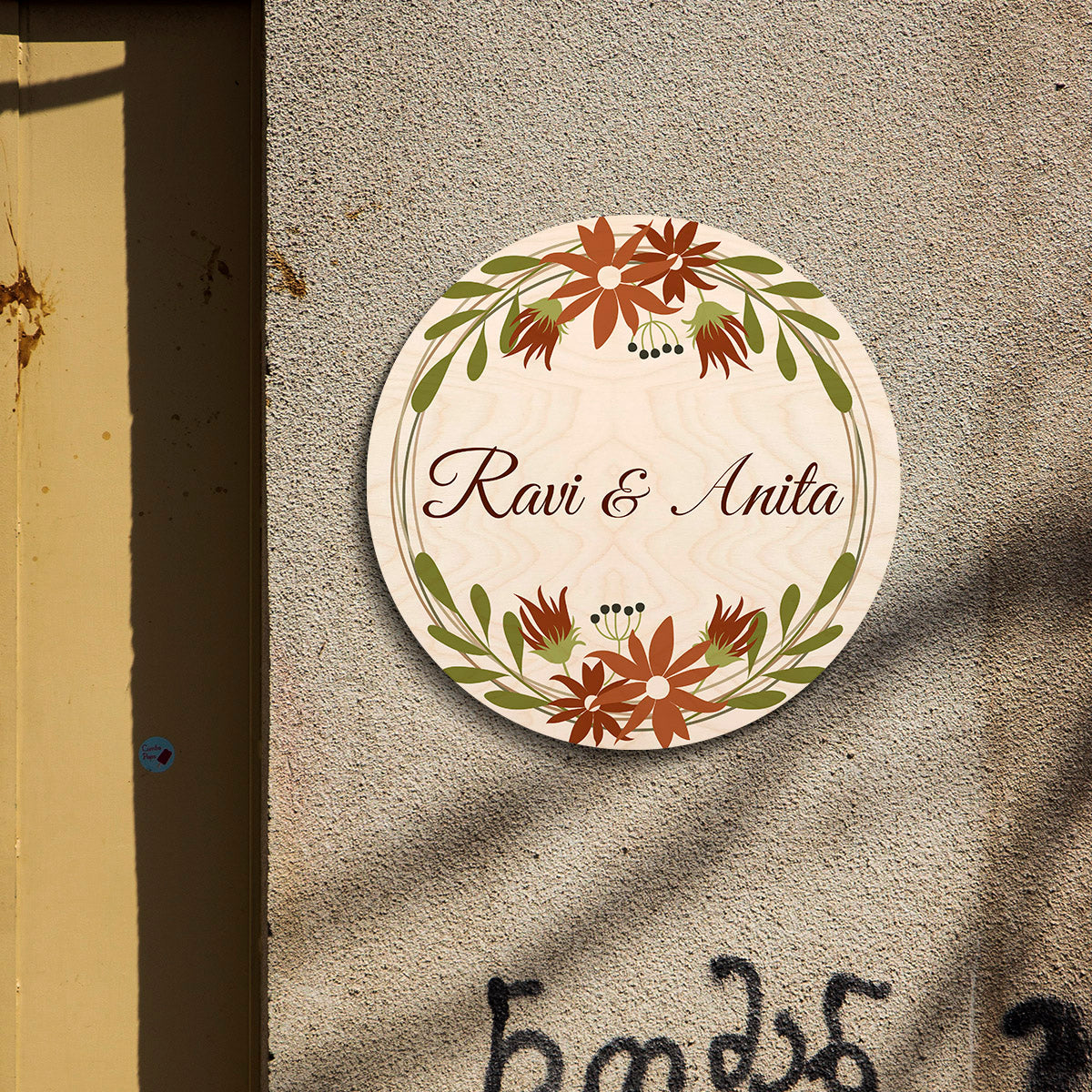 Floral round name board styled on apartment entrance with cream birch and wreath
