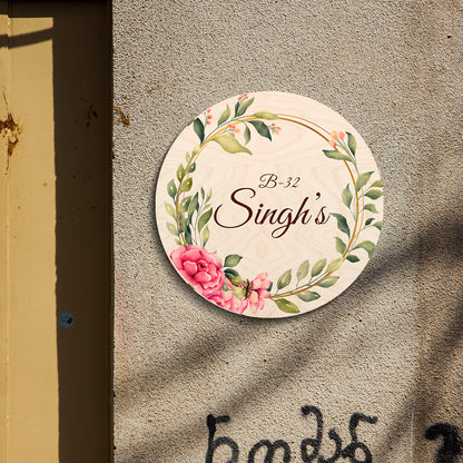 Round couple name plate displayed by a front door, two names in warm brown script