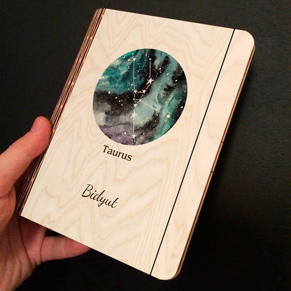 Alternate angle on the personalized diary, showing teal-blue nebula with Taurus V-shape Hyades cluster and, in birch wood.