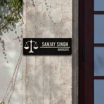 Slim black advocate name plate on an office door with raised wooden letters