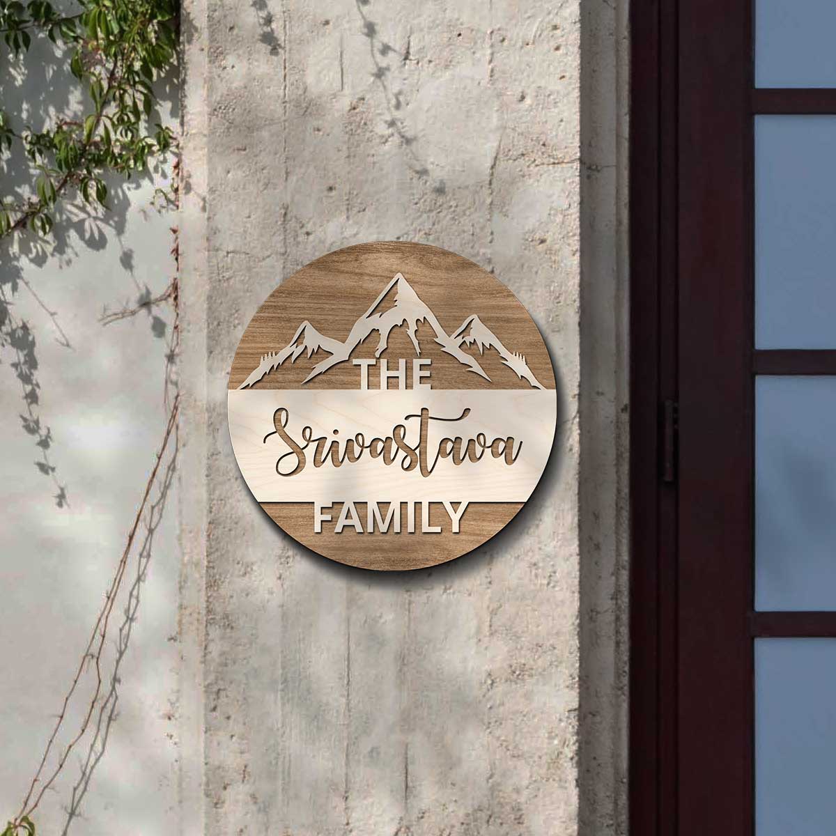 Mountain top design family name plate with snow-capped peaks and surname on brown wood
