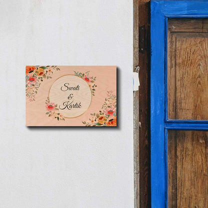 Close-up of orange and peach florals around gold circle on name board for flat