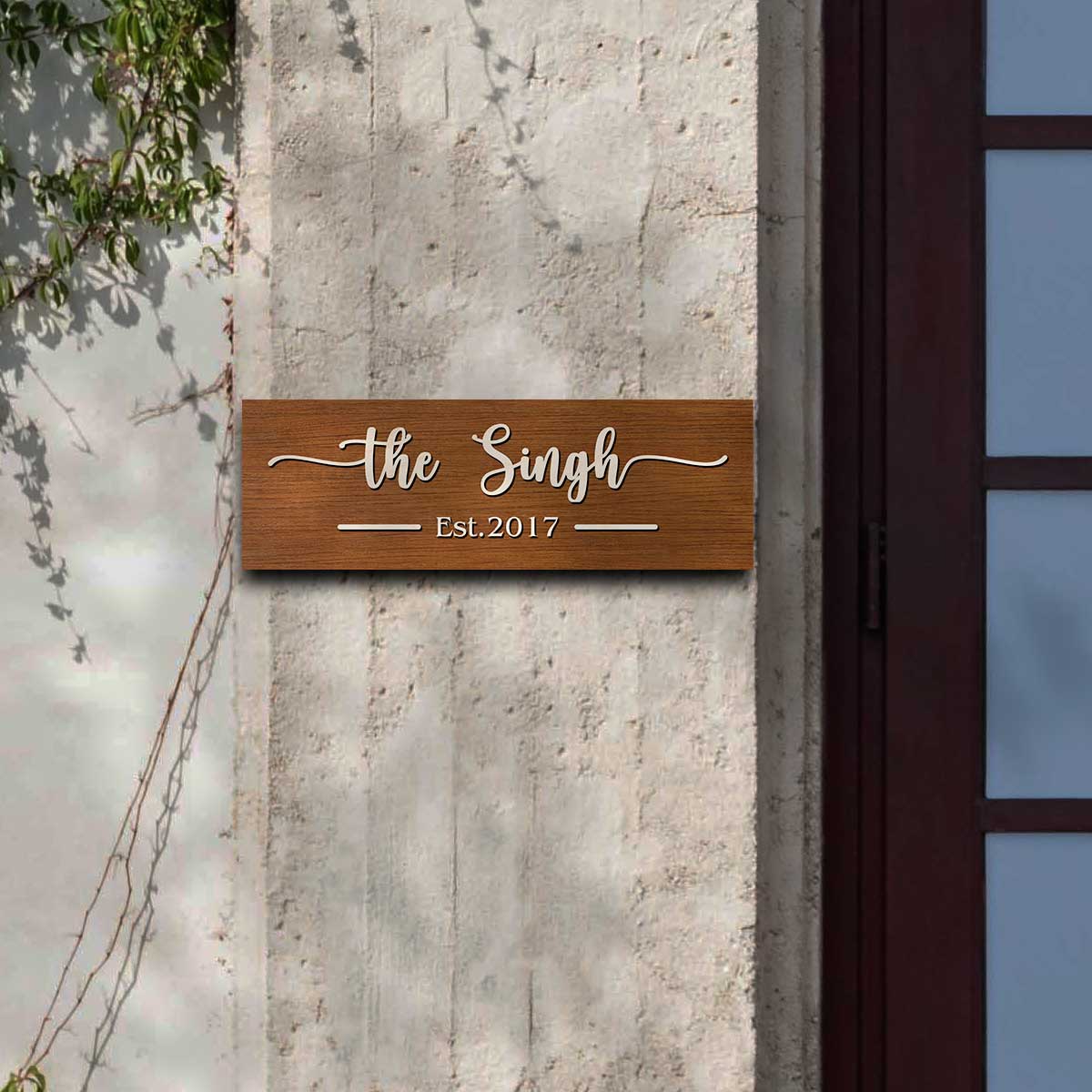 Close-up of cream raised cursive letters on the 3D wooden name plate brown rectangle