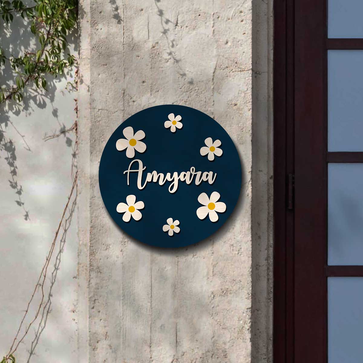 Round navy kids name plate with raised white daisies and a child's name in 3D cursive