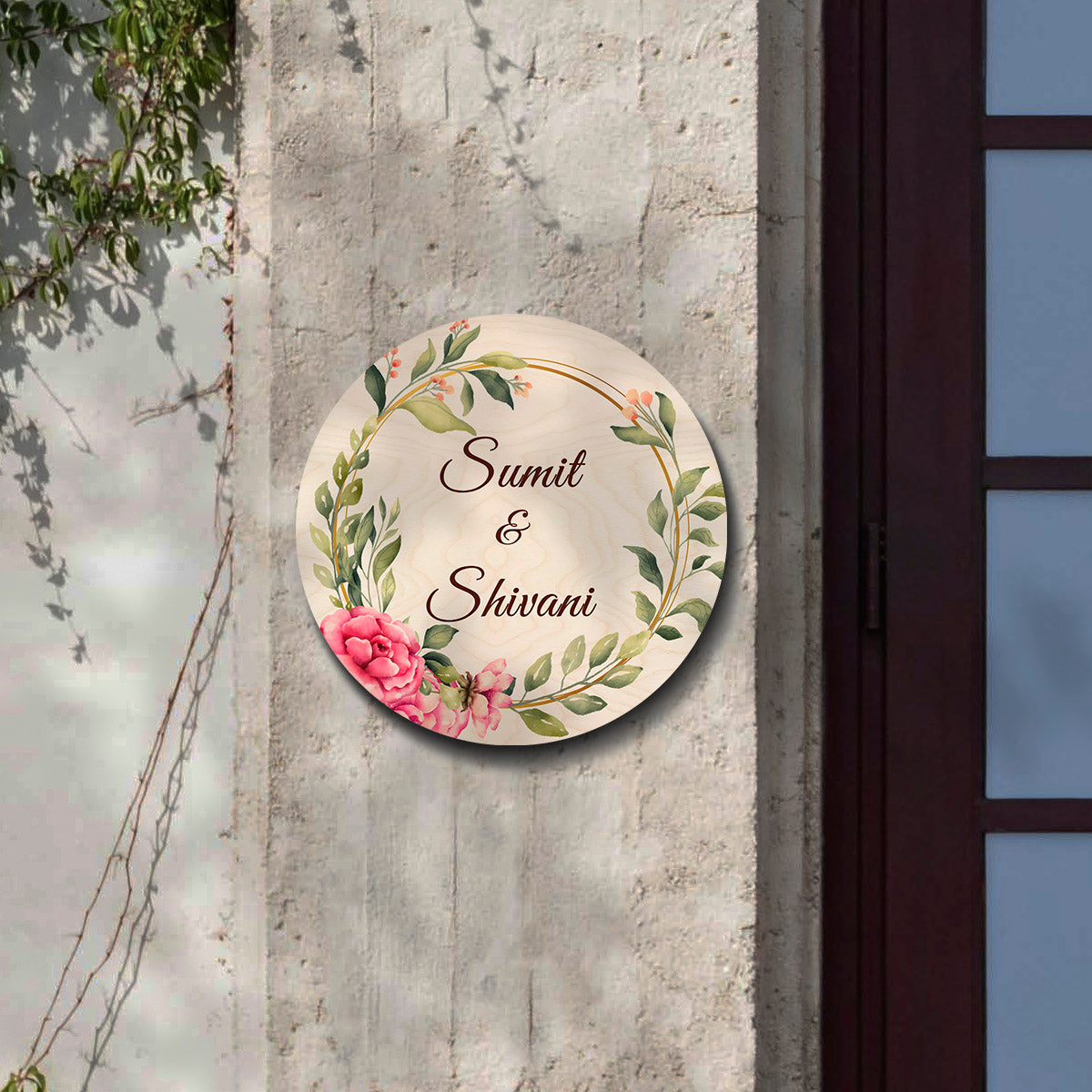 Close-up of pink blooms, berries and greenery wrapping the golden ring on the nameplate