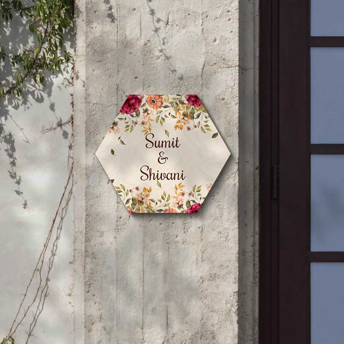 Close-up of watercolour blooms in red, peach and mustard on hexagon name plate