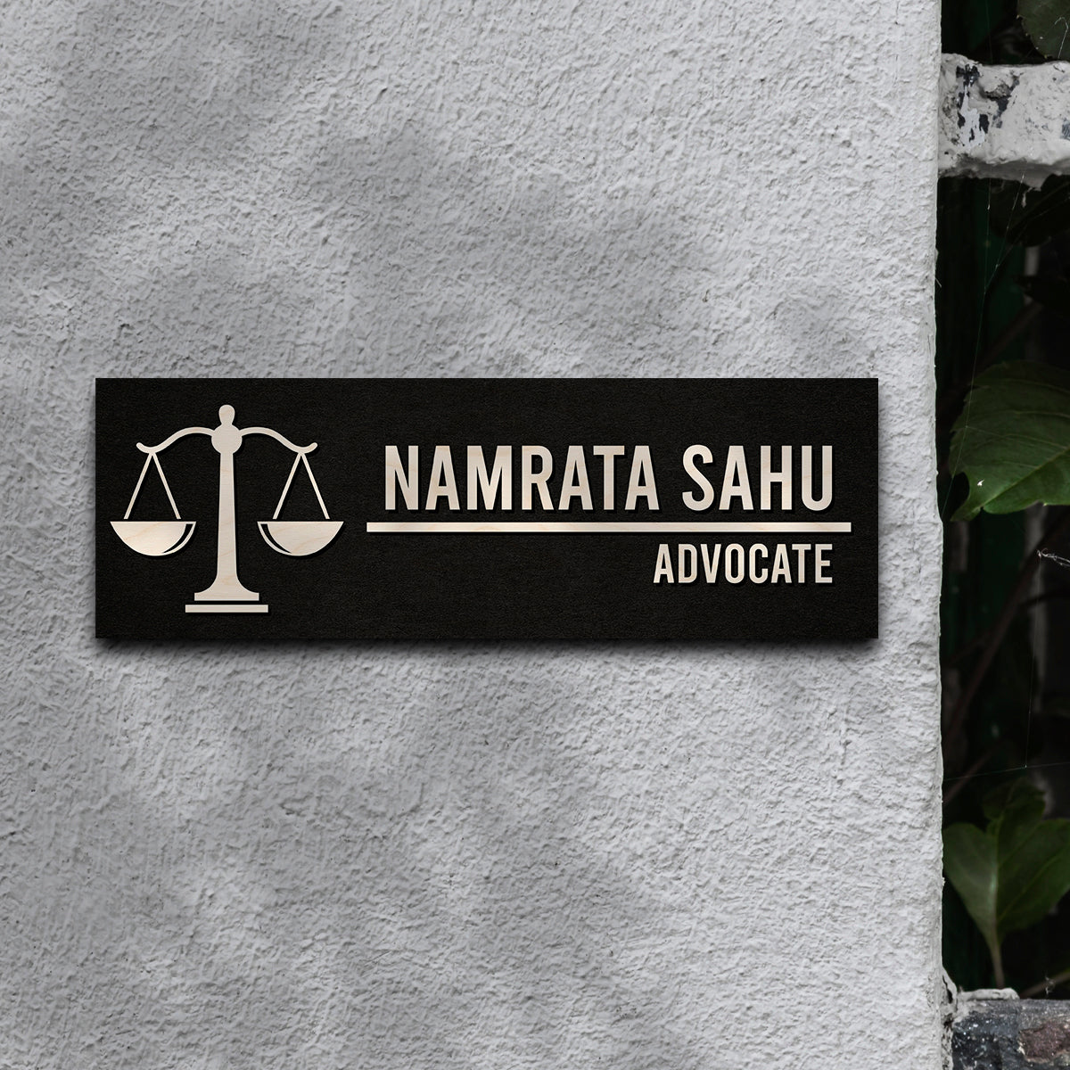 Advocate name plate with the word ADVOCATE below a bold name on black wood
