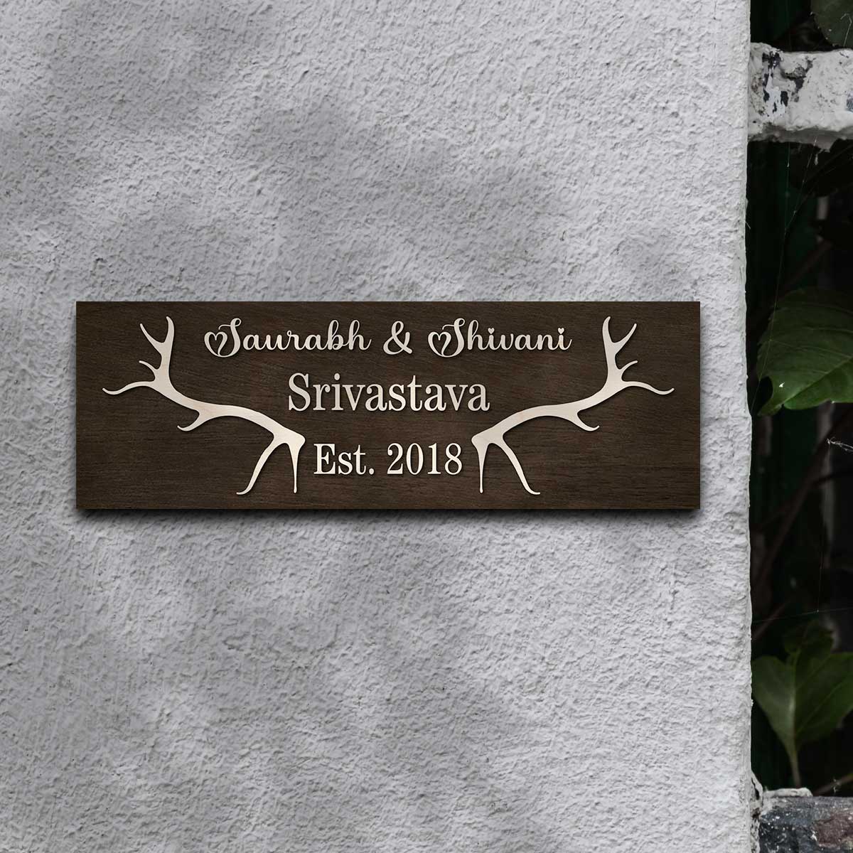 New home name plate with cream antlers, couple names and family name on dark wood